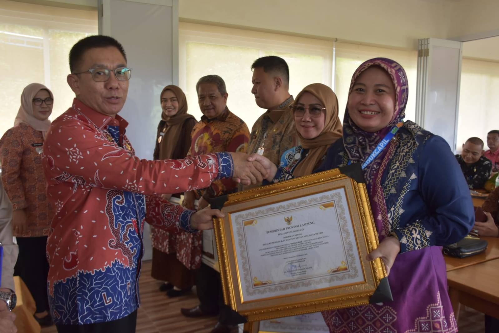 Penyerahan Piagam Penghargaan kepada Dinas Kependudukan dan Pencatatan Sipil Kota Metro atas Perolehan Predikat Kinerja “Sangat Baik”